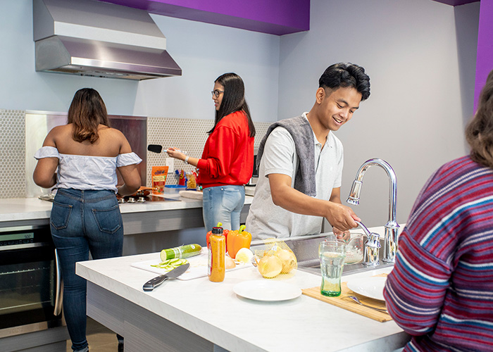 Four students using the kitchen