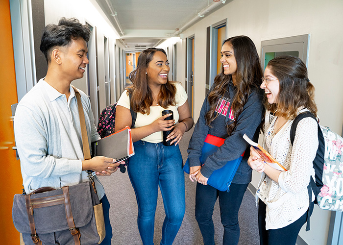 Four students talking in a hallway