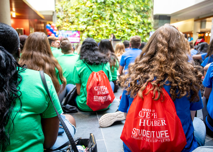 In audience, behind seated students