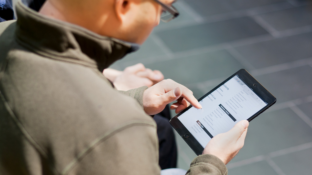 Over the shoulder view of student using tablet