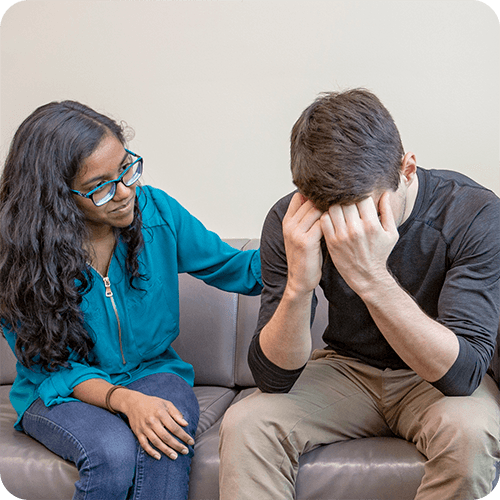 Woman on couch speaking with distraught man