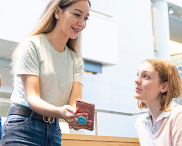 Student showing another student a mobile phone