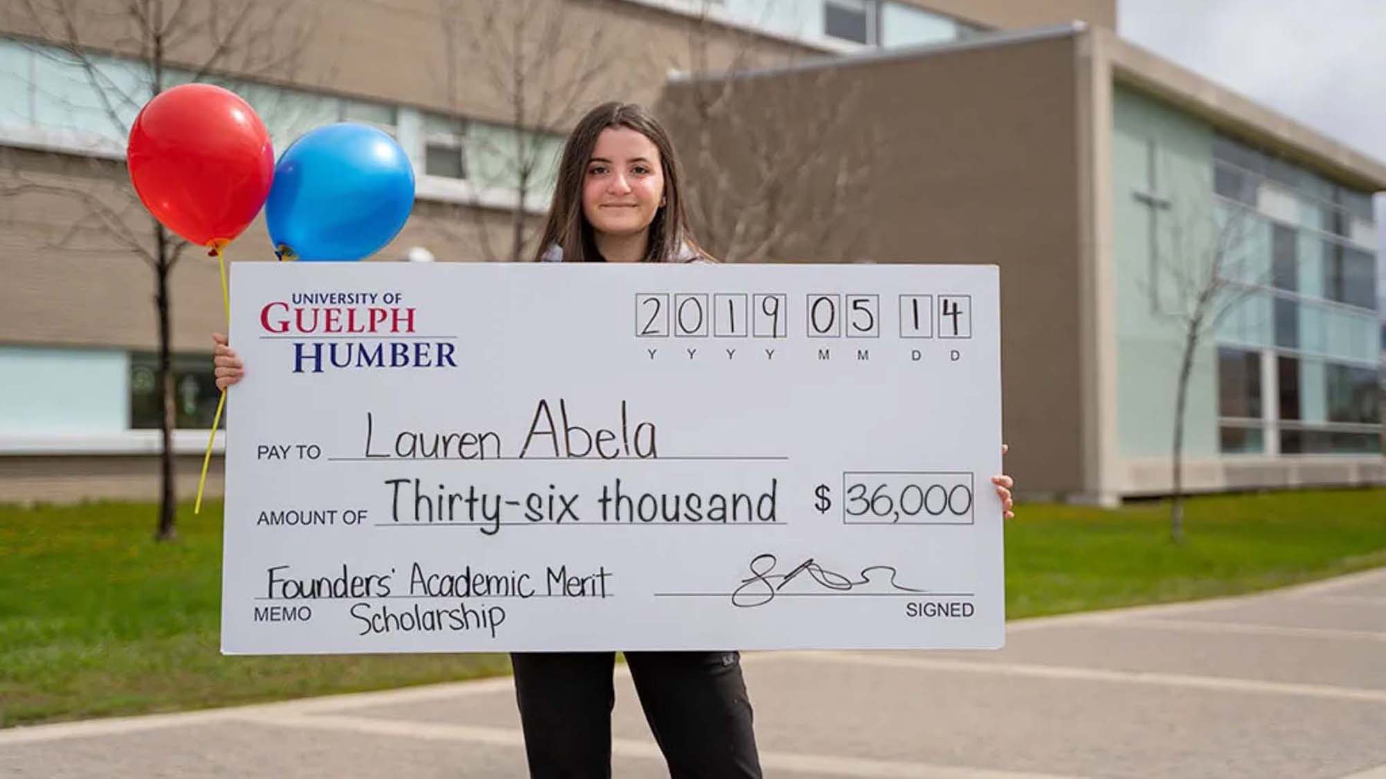Student holding giant cheque