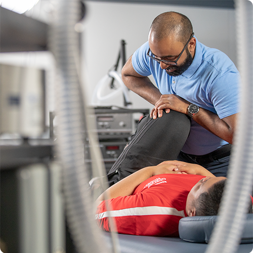 Man assessing patient's leg