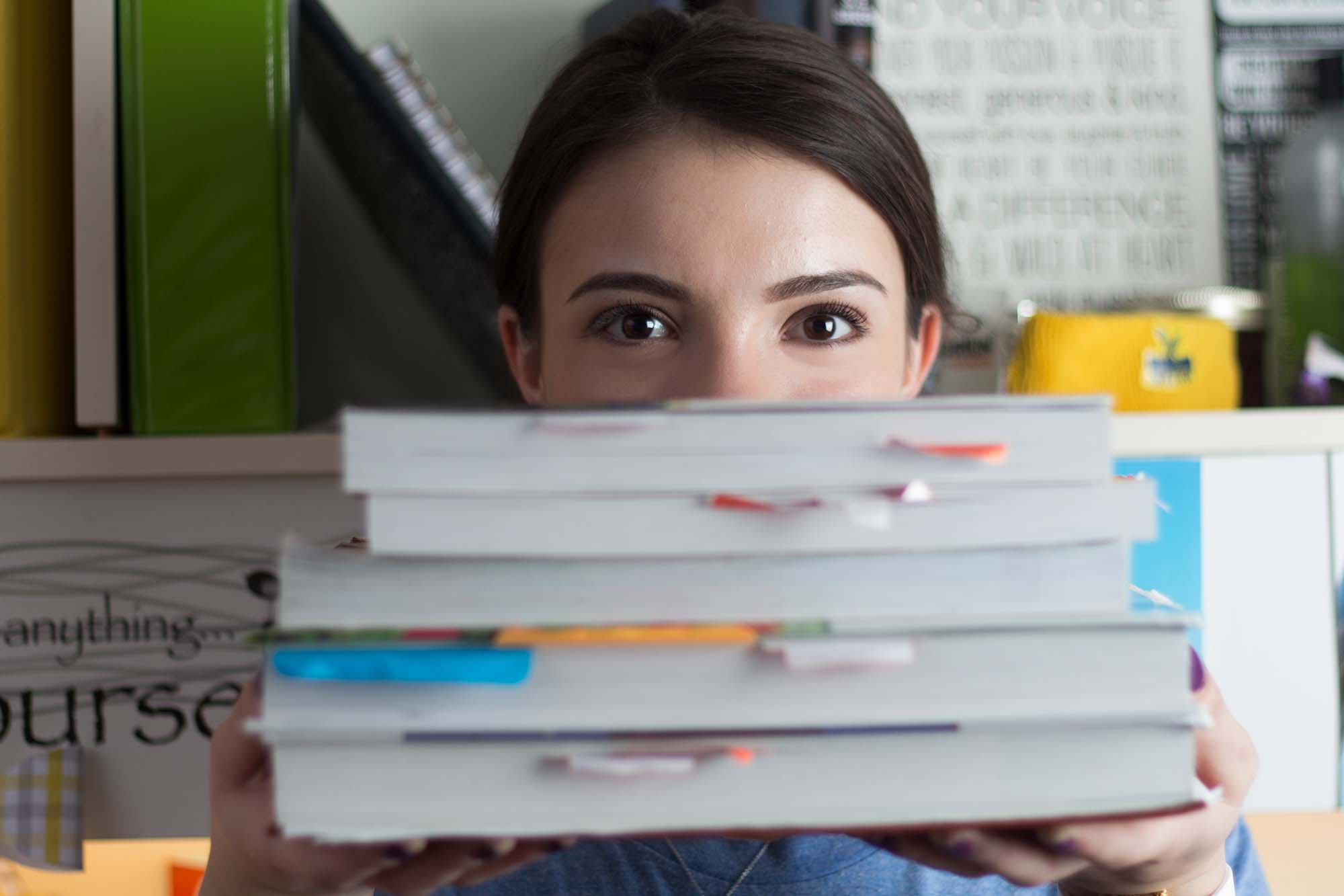 student holding stack of books