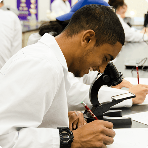 Student looking into microscope