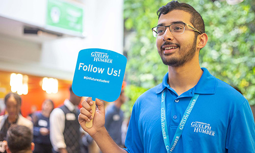 Tour guide holding a 'Follow Us' sign