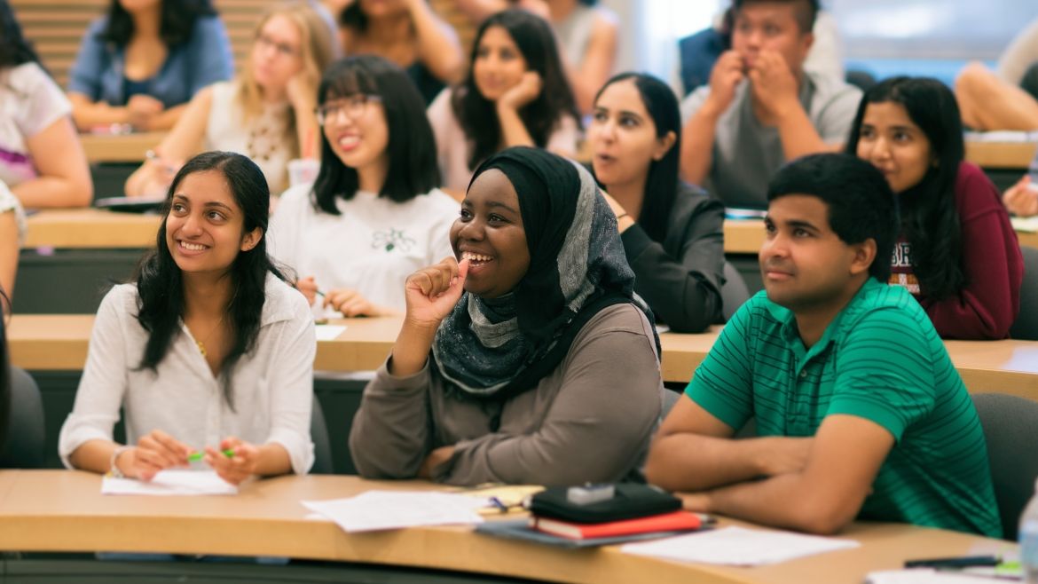 Group of students sitting in tiered seating in a classroom setting