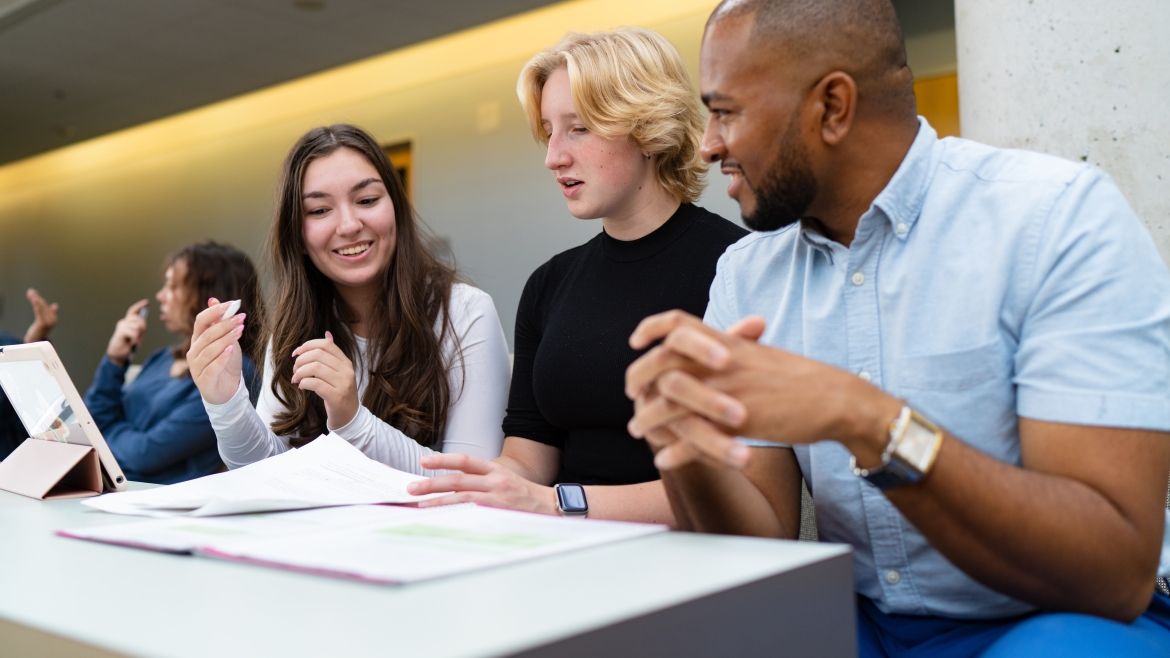 Three students sitting at a desk working together