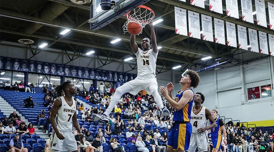 Someone making a slam dunk while three other players look on