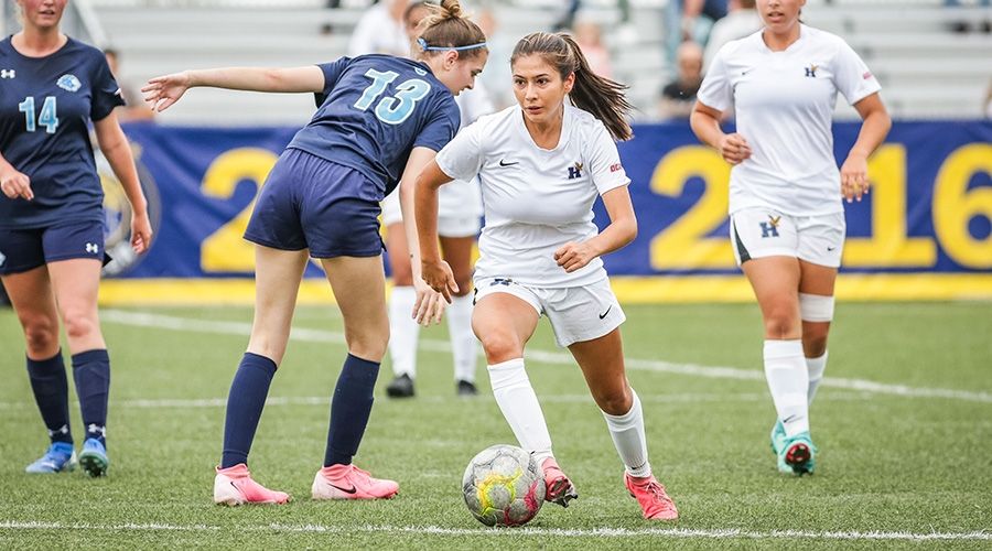 Someone dribbling a soccer ball past another player