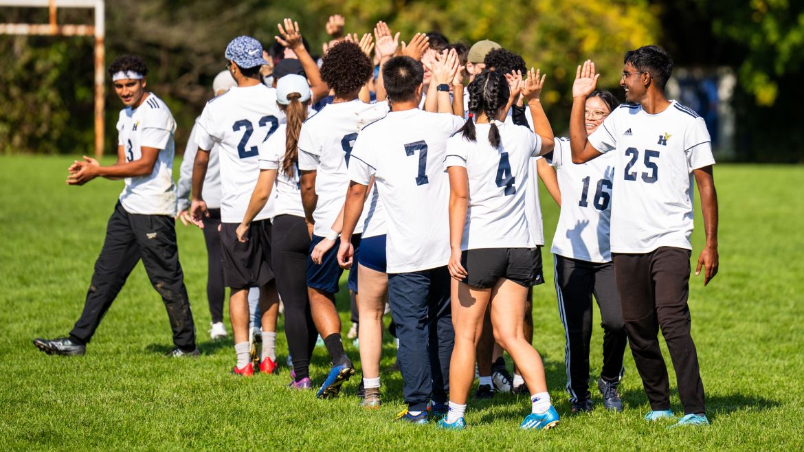 A group of student athletics lined up to high-five one another