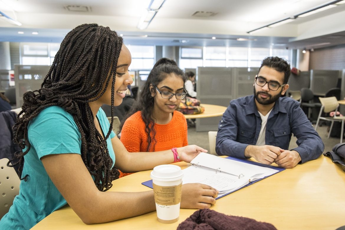 three students studying at desk