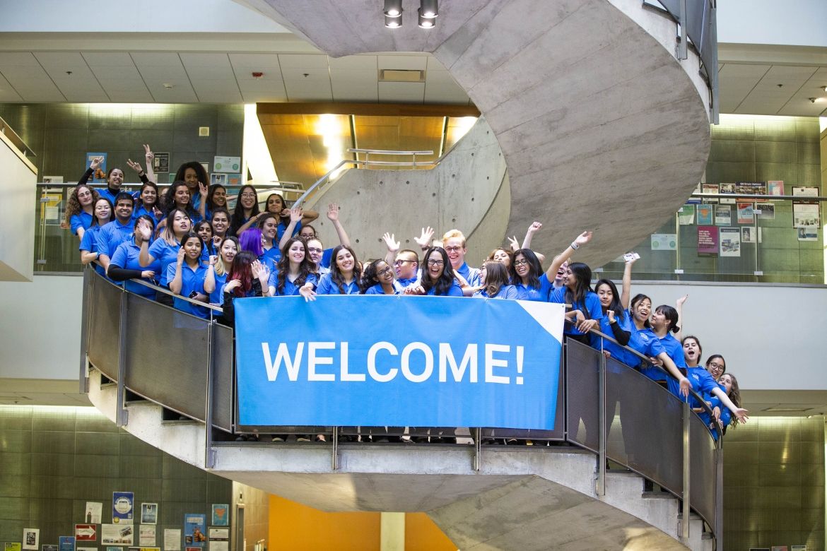 group on staircase with welcome sign