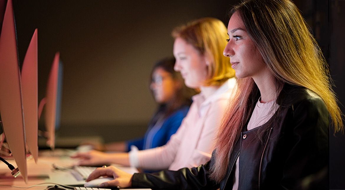 Three students looking at computers