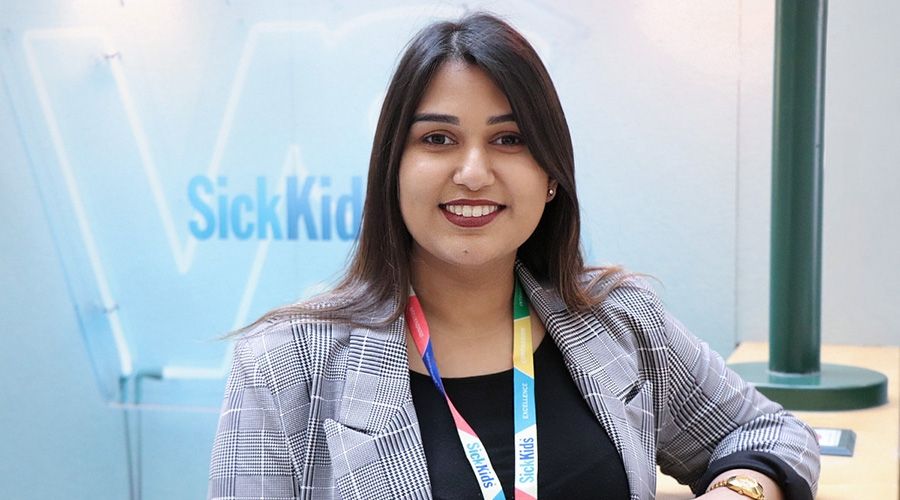 intern in front of sick kids sign