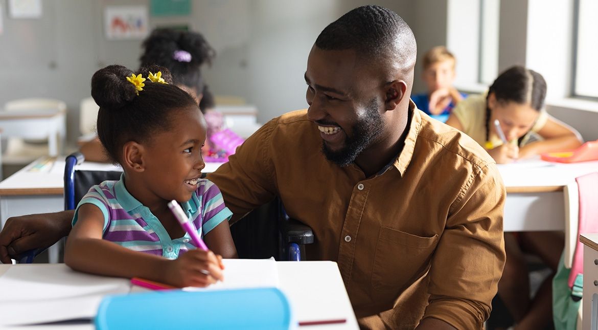 male teacher helping student draw