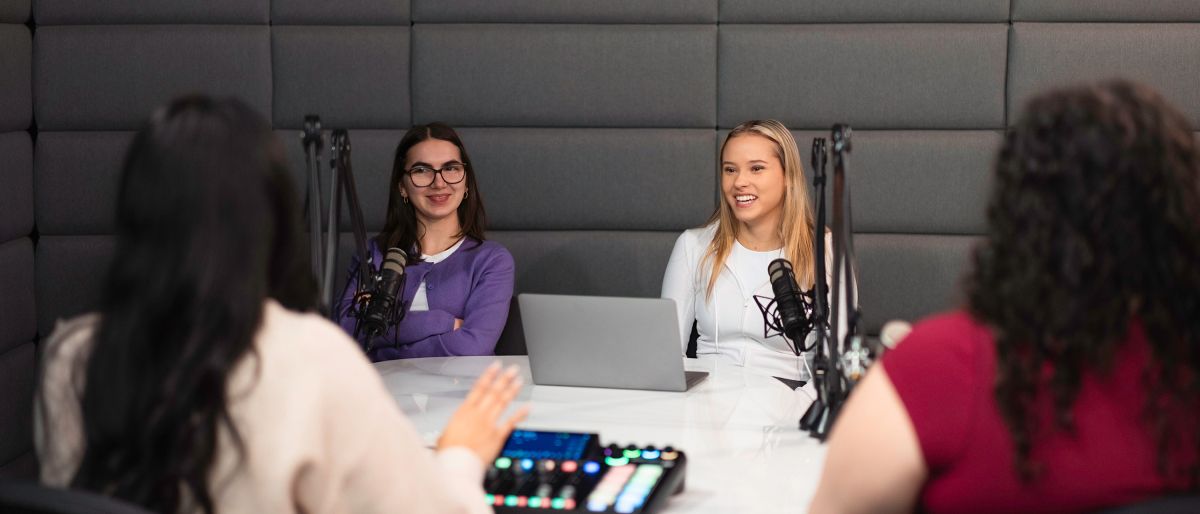 four students in podcast studio