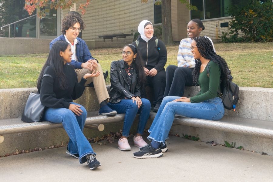Six people sitting outside talking to each other