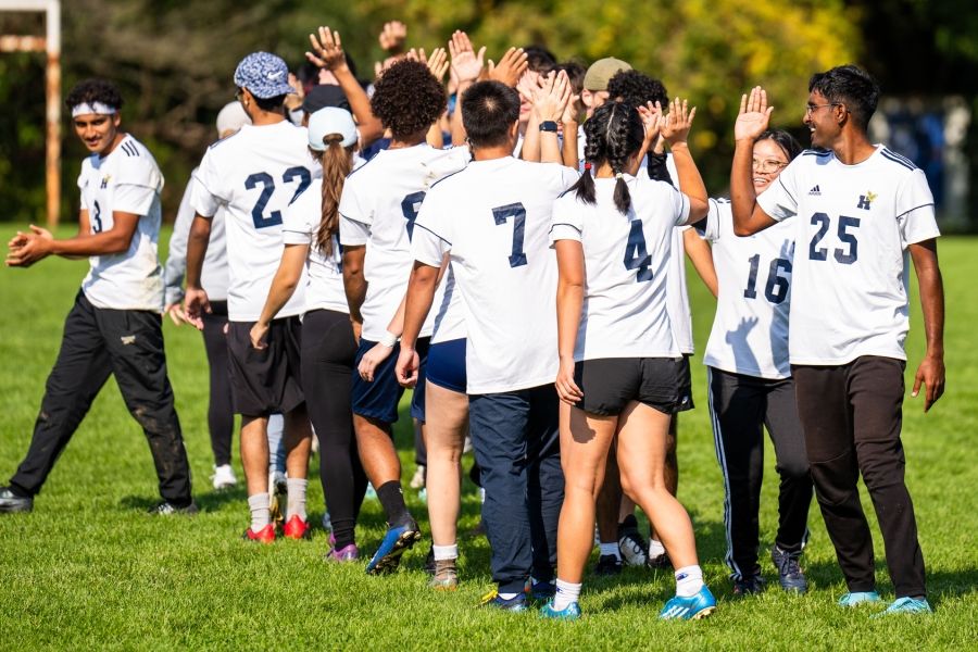 A group of student athletics lined up to high-five one another