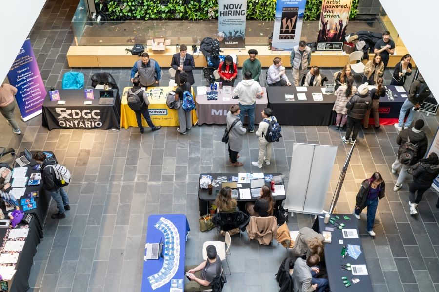 Career fair with tables and people milling, view from above