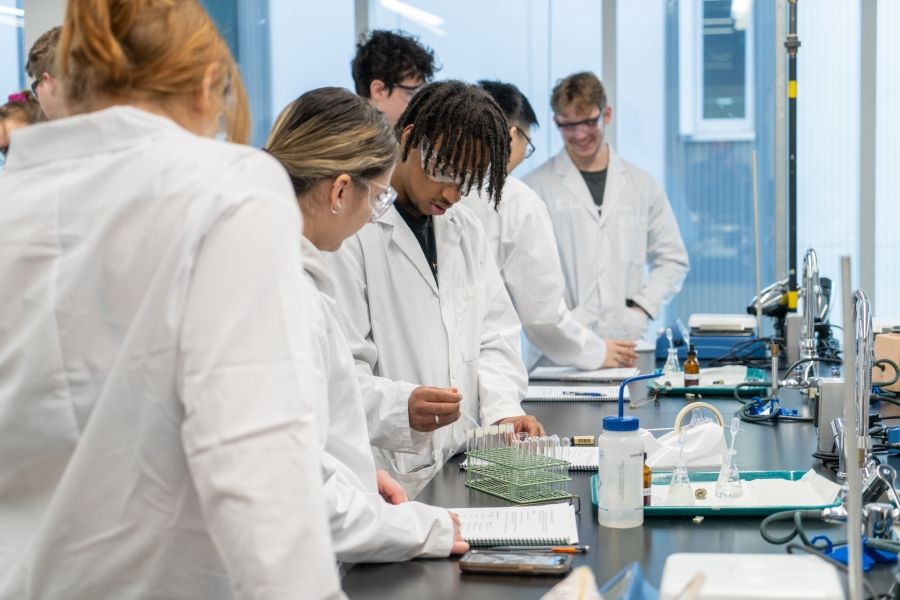 Group of students in lab coats working in a wet lab
