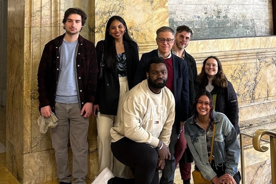 A group of students and faculty member together in front of a piece of art