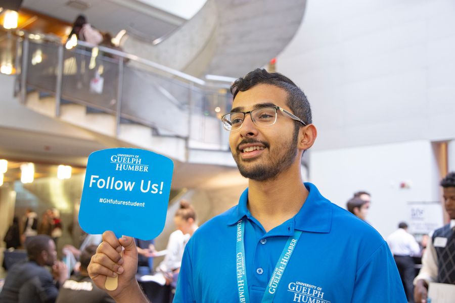 Student holding tour sign