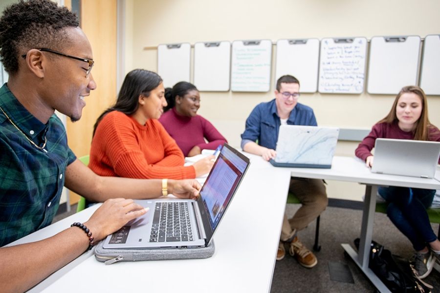Five students having a discussion in a classroom