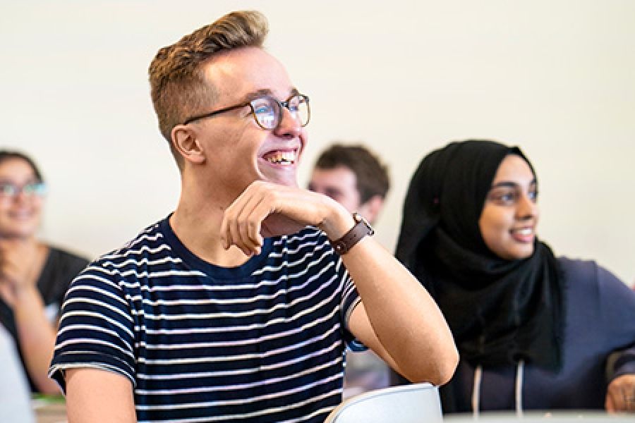 Male student with hand under chin in classroom