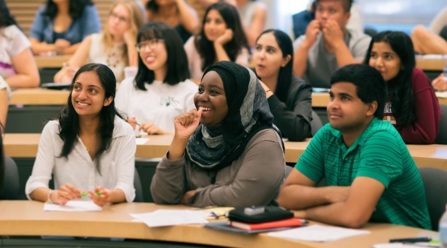 Group of students sitting in tiered seating in a classroom setting
