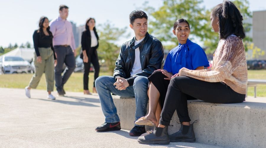Students sitting together outside the UofGH building