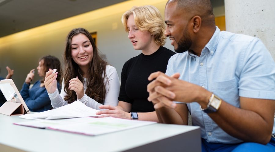 Three students sitting at a desk working together