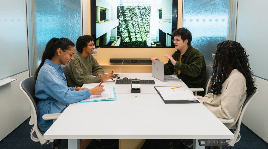 Four students sitting at a table together doing homework